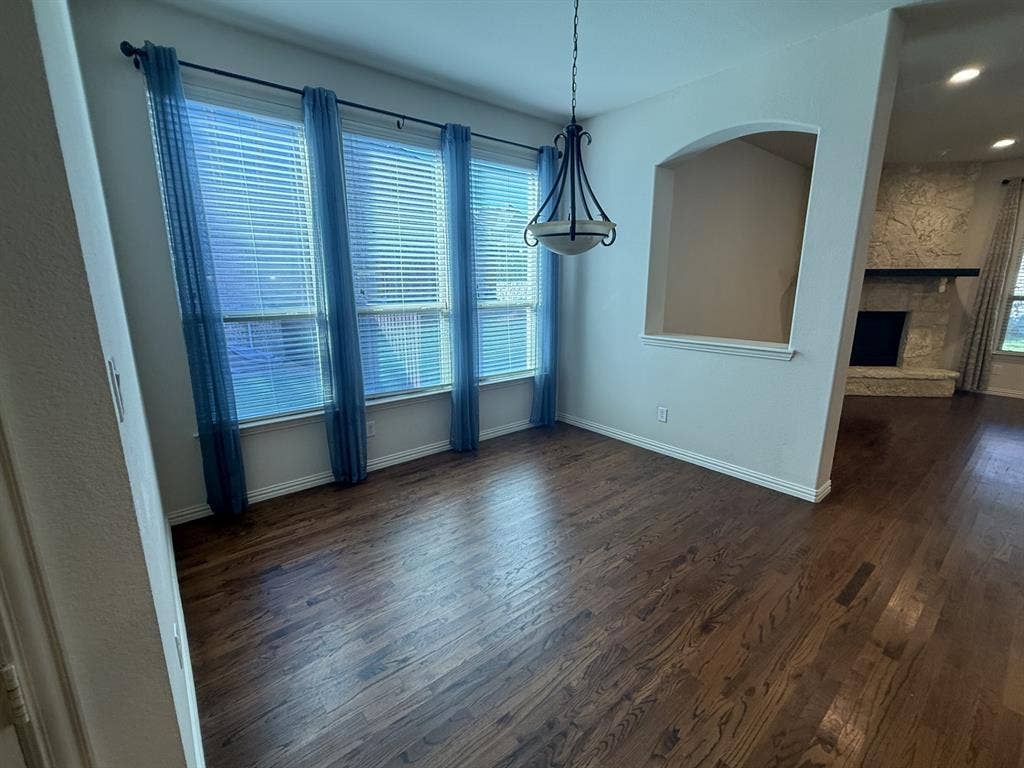 13721 Vera Cruz Road, Frisco, TX 75035 Hardwood-finish flooring with a decorative chandelier, multiple windows with blinds, and an integrated wall niche
