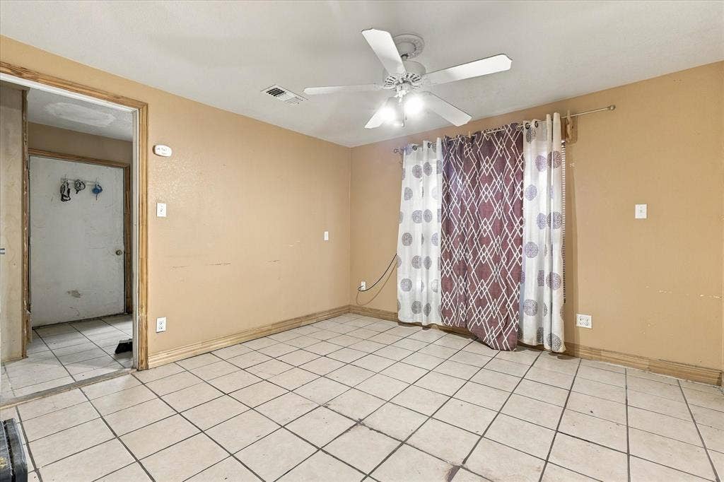 Interior space featuring light-toned ceramic tile flooring and a ceiling-mounted fan with integrated lighting