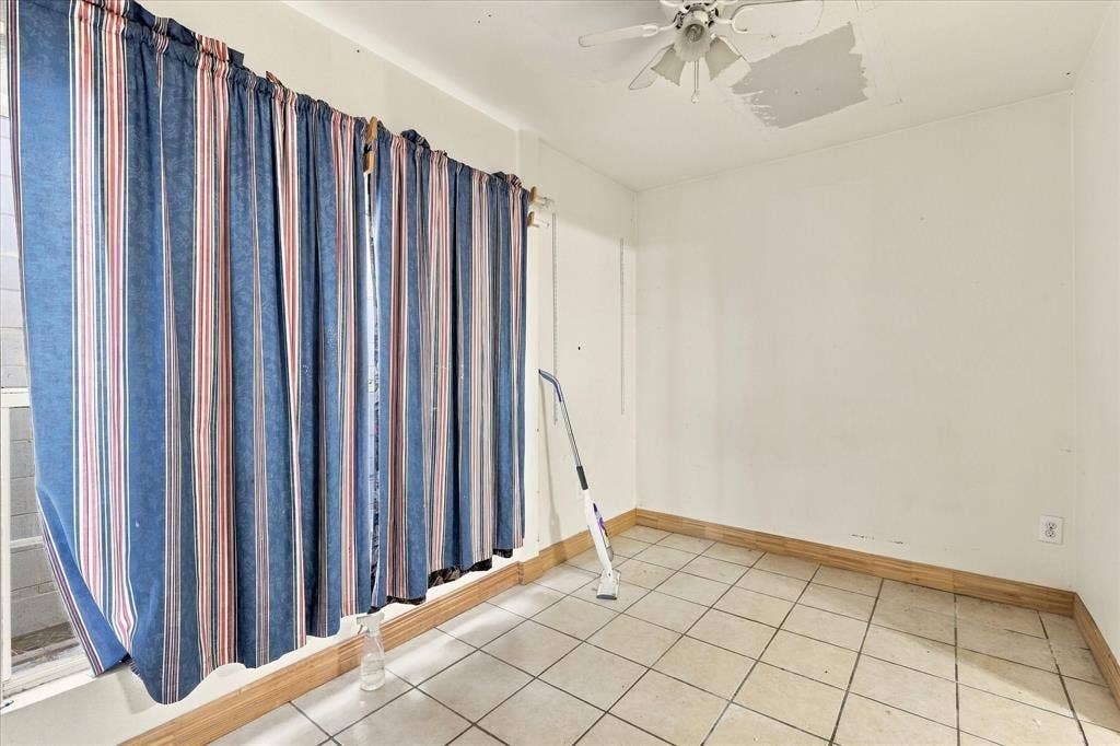 Room featuring white walls, tile flooring, and a ceiling-mounted light fixture