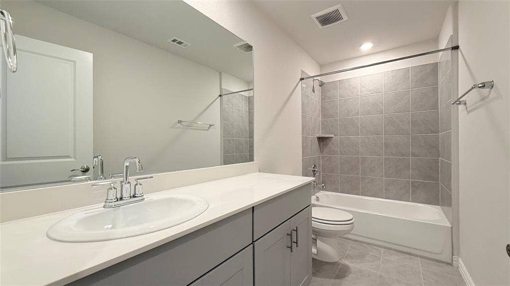531 Deer Canyon Way, Princeton, TX 75407 Bathroom featuring a vanity with a white countertop and undermount sink, a large wall-mounted mirror, a tiled shower-tub combination with a built-in niche, and tiled flooring