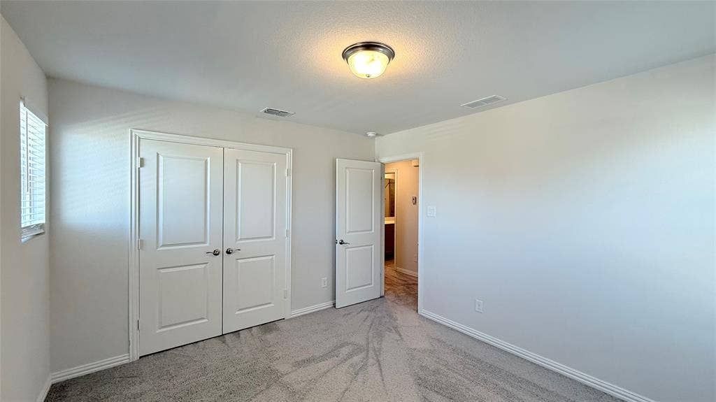 531 Deer Canyon Way, Princeton, TX 75407 Interior room with soft gray carpeting, white painted walls, and a window with white blinds
