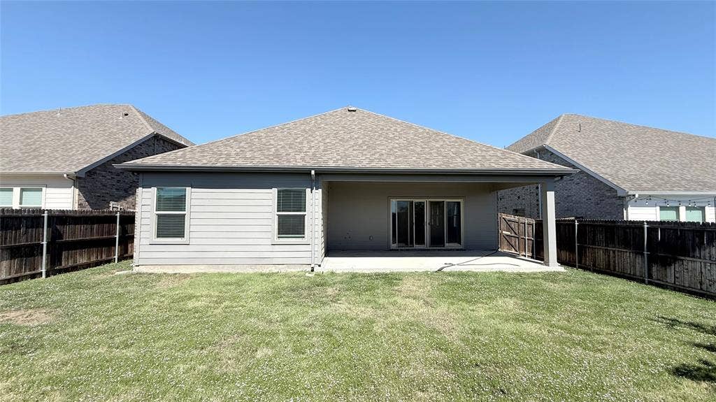 531 Deer Canyon Way, Princeton, TX 75407 Expansive lawn with a covered patio featuring a concrete slab and sliding glass doors