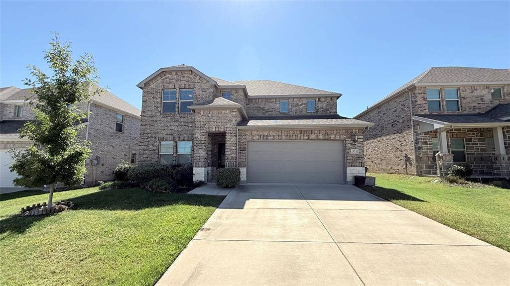 531 Deer Canyon Way, Princeton, TX 75407 Two-story residential exterior featuring a brick and stone facade, an attached two-car garage, and a concrete driveway