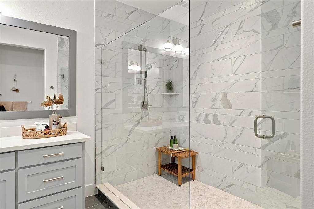 1137 Manderly Court, Dallas, TX 75204 Glass-enclosed shower with subway tile surround, mosaic tile flooring, and a rainfall showerhead