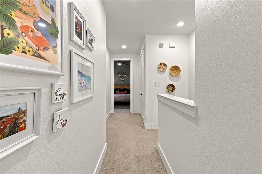 1137 Manderly Court, Dallas, TX 75204 Recessed lighting illuminates the hallway, featuring light-colored carpeting and white walls