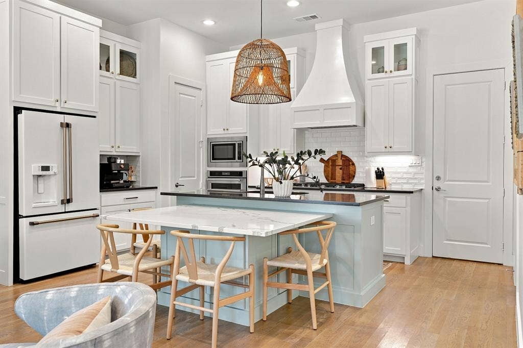 1137 Manderly Court, Dallas, TX 75204 Contemporary kitchen featuring white cabinetry, a built-in refrigerator, wood-finish flooring, a light blue kitchen island with a white countertop, and an integrated range hood