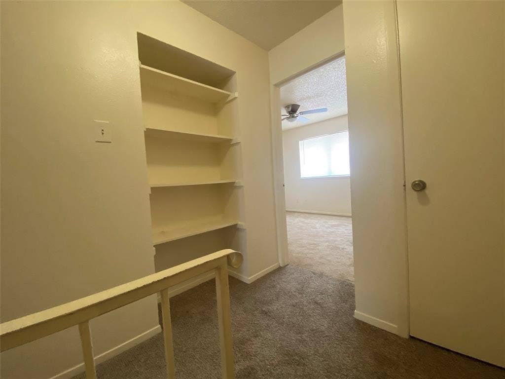 2802 Wimbledon Court, #B, Garland, TX 75041 Corridor featuring dark carpet and baseboards