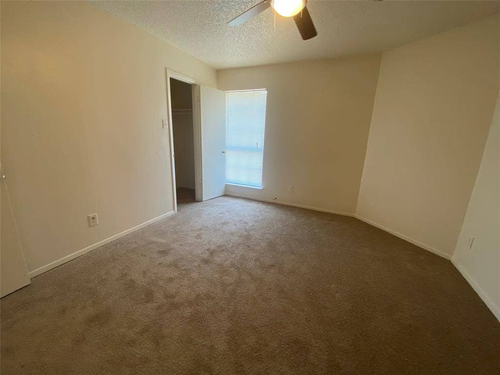 2802 Wimbledon Court, #B, Garland, TX 75041 Spare room featuring baseboards, a ceiling fan, a textured ceiling, and carpet flooring