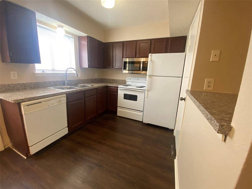 2802 Wimbledon Court, #B, Garland, TX 75041 Kitchen with a textured ceiling, white appliances, dark wood-style floors, and a sink