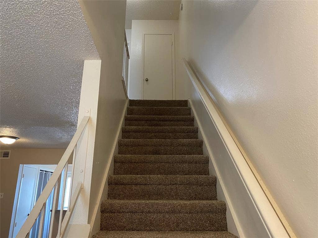 2802 Wimbledon Court, #B, Garland, TX 75041 Stairs with a textured ceiling and visible vents