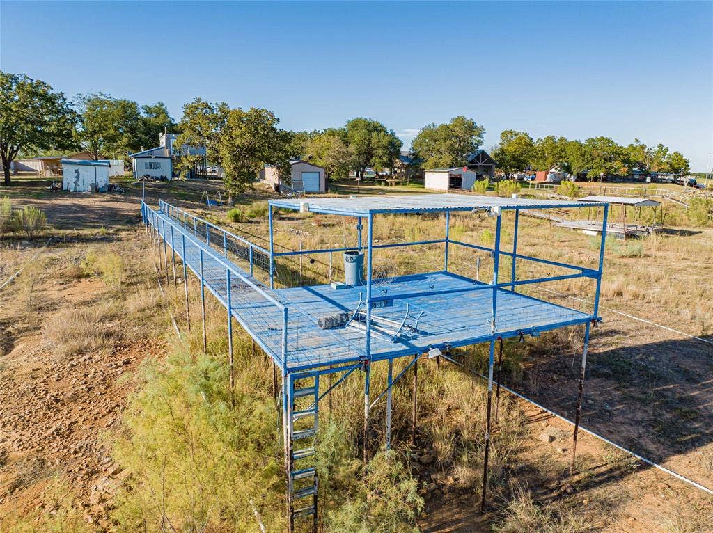Elevated metal deck with a covered area, accessed by a metal walkway and an attached ladder