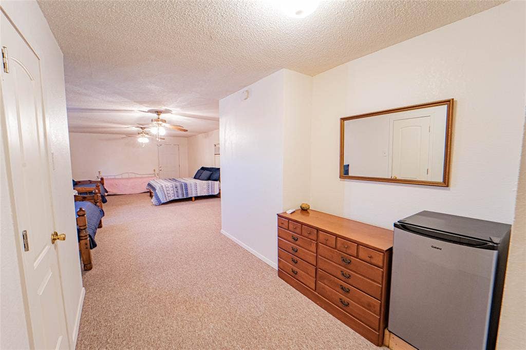 Spacious room with neutral carpeting and a textured ceiling