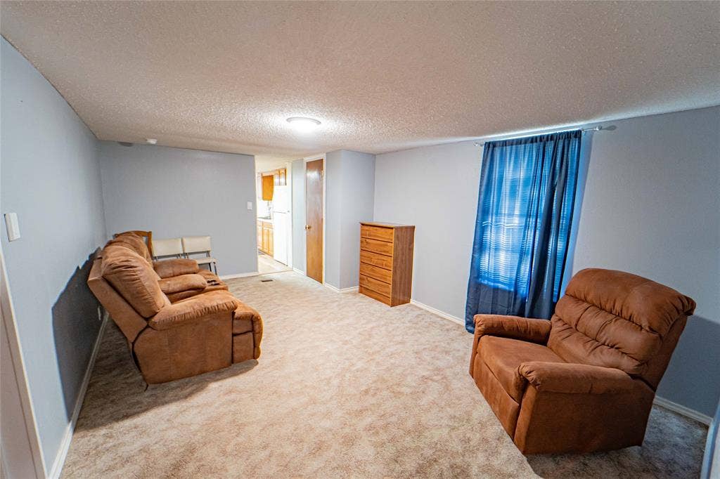 Neutral wall color, carpeted flooring, and an overhead light fixture
