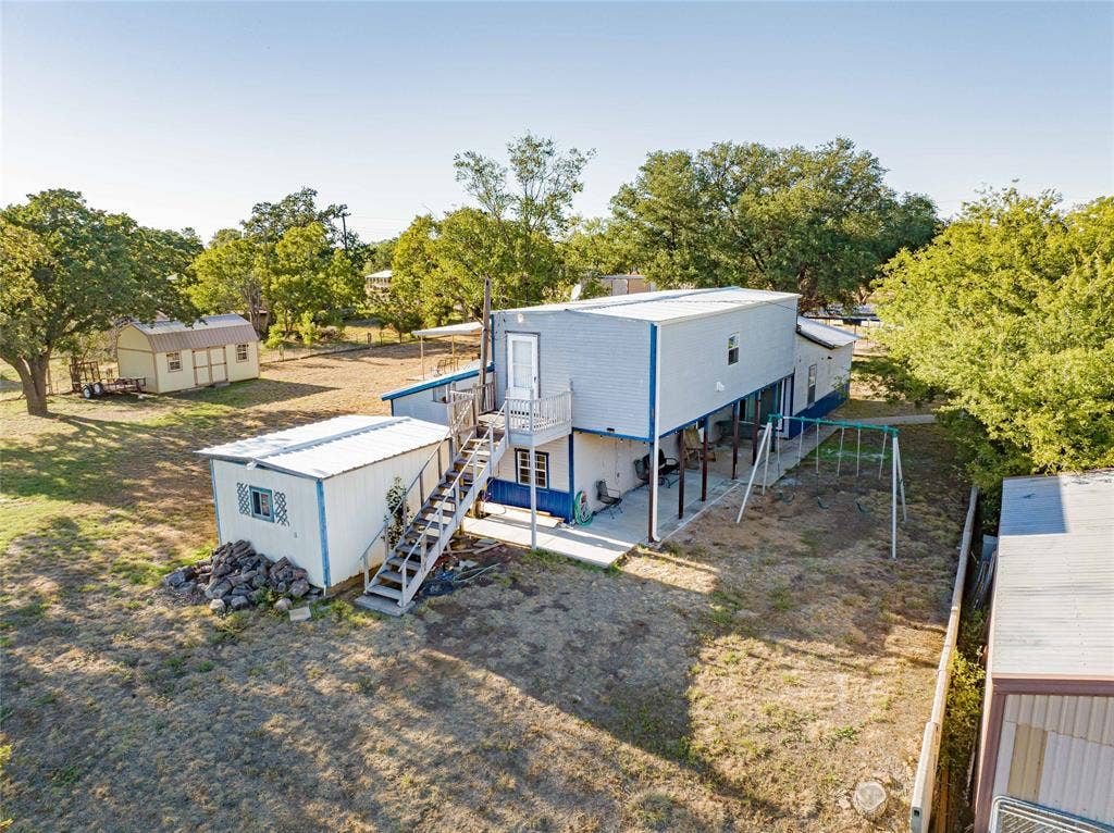 Elevated residential structure featuring a white exterior with blue trim