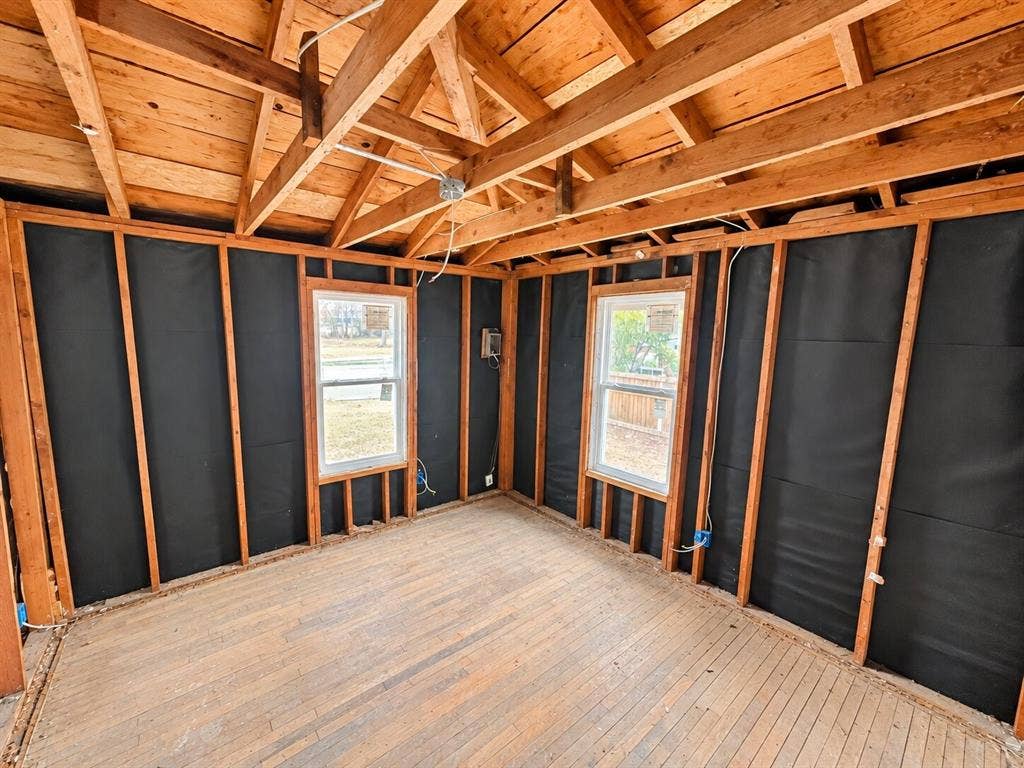 4604 Avenue H, Fort Worth, TX 76105 Exposed wood-frame construction with two windows, original wood flooring, and visible ceiling joists