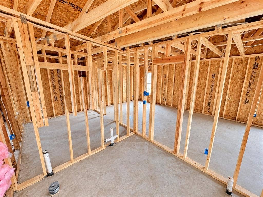 4604 Avenue H, Fort Worth, TX 76105 Unfinished interior framing with exposed wooden studs, concrete flooring, and visible plumbing rough-ins
