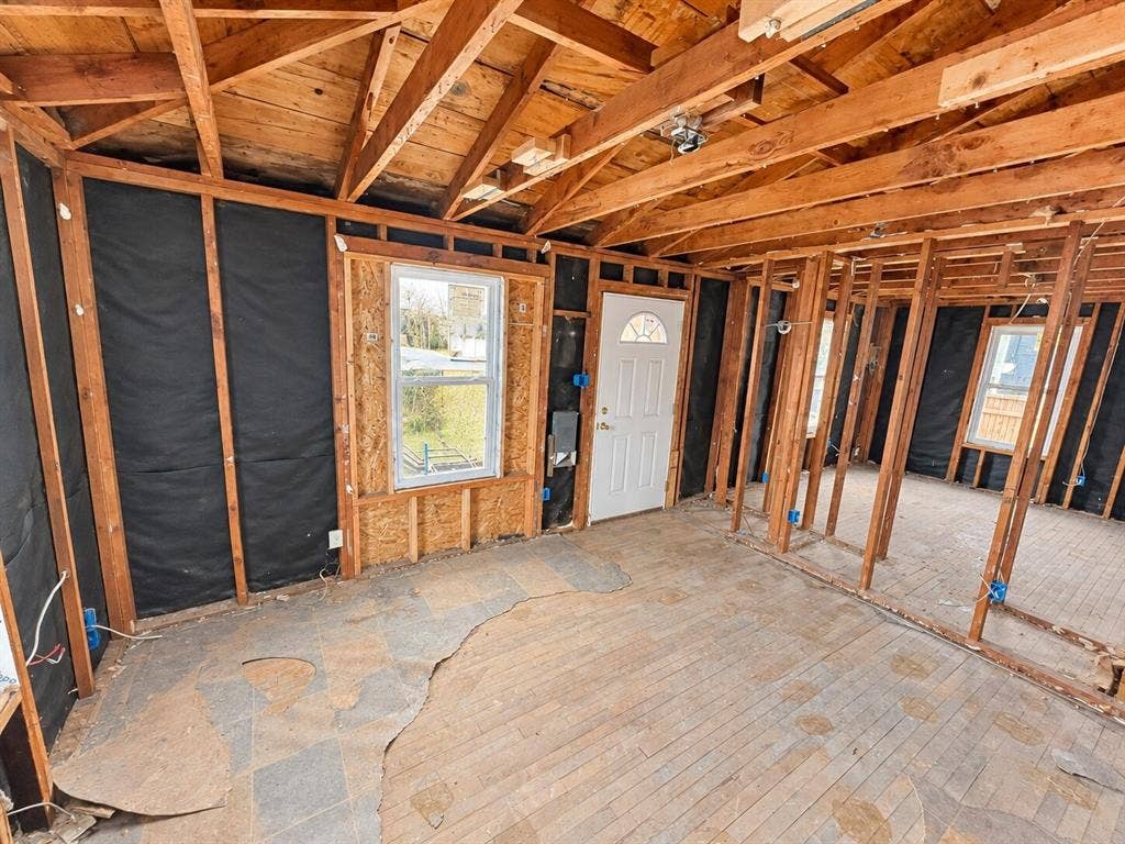 4604 Avenue H, Fort Worth, TX 76105 Exposed wood framing, visible ceiling joists, and a white entry door with an arched glass insert