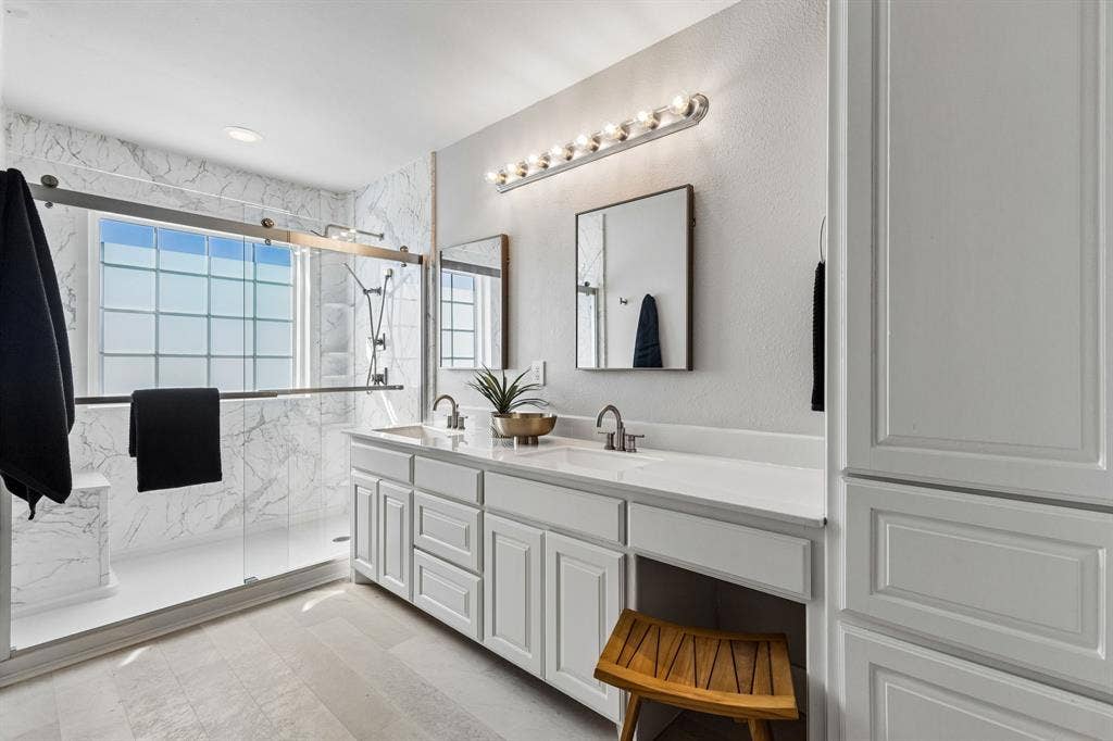 706 S Jupiter Road, #307, Allen, TX 75002 Large walk-in shower, dual vanity with integrated sinks and white countertops, complemented by white cabinetry and a built-in storage tower
