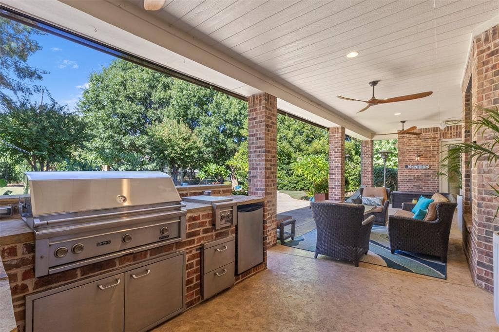 15600 Big Horn Trail, Frisco, TX 75035 Covered outdoor patio featuring brick pillars, wood-paneled ceiling, and two ceiling fans