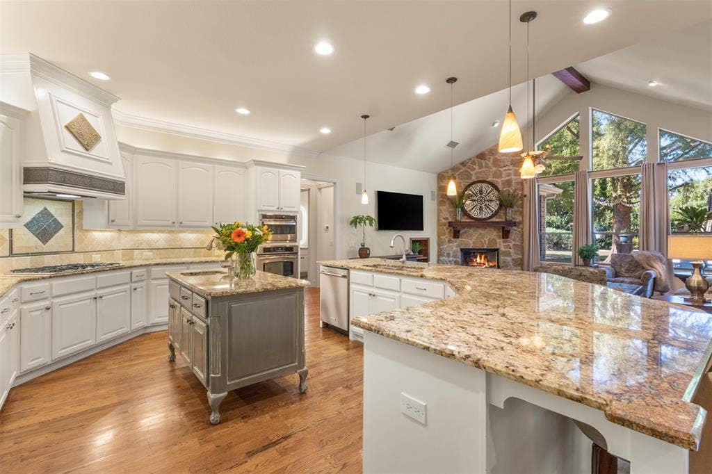 15600 Big Horn Trail, Frisco, TX 75035 Kitchen features a large island, wood-finish flooring, and white cabinetry