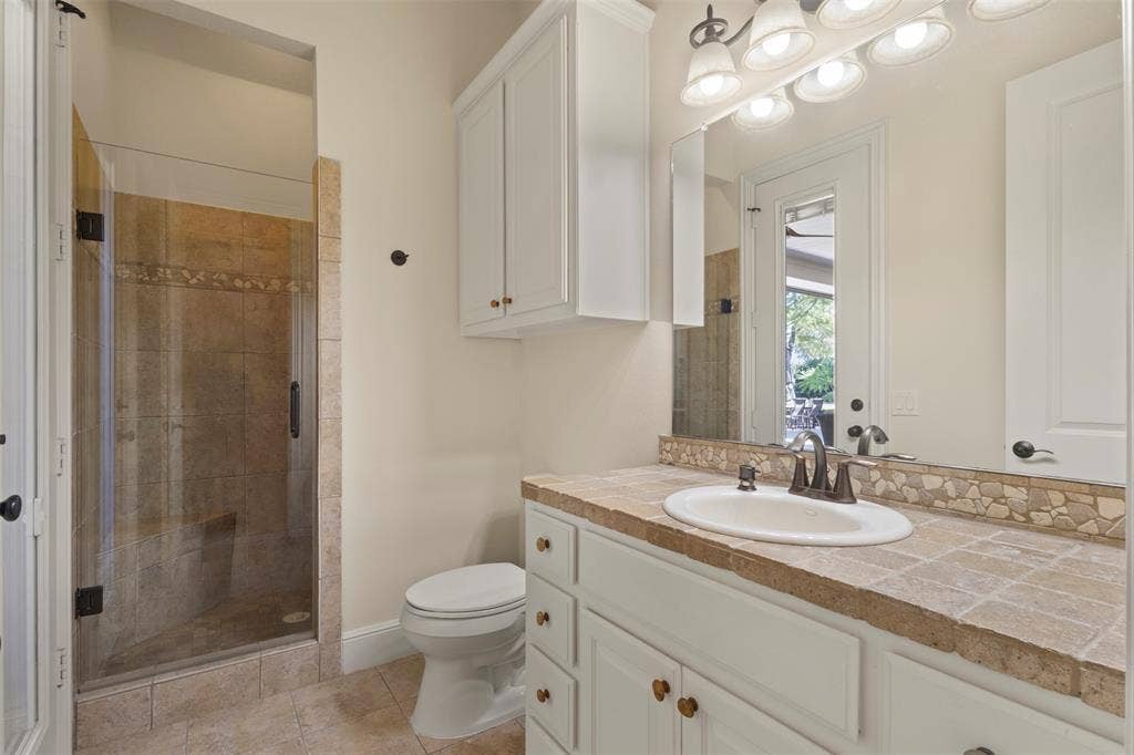 15600 Big Horn Trail, Frisco, TX 75035 White vanity with a tile countertop, integrated sink, and an oil-rubbed bronze faucet