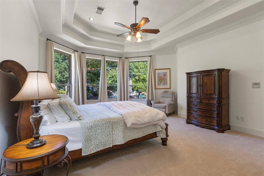15600 Big Horn Trail, Frisco, TX 75035 Tray ceiling with crown molding, ceiling fan, recessed lighting, bay windows with drapery, and carpeted flooring