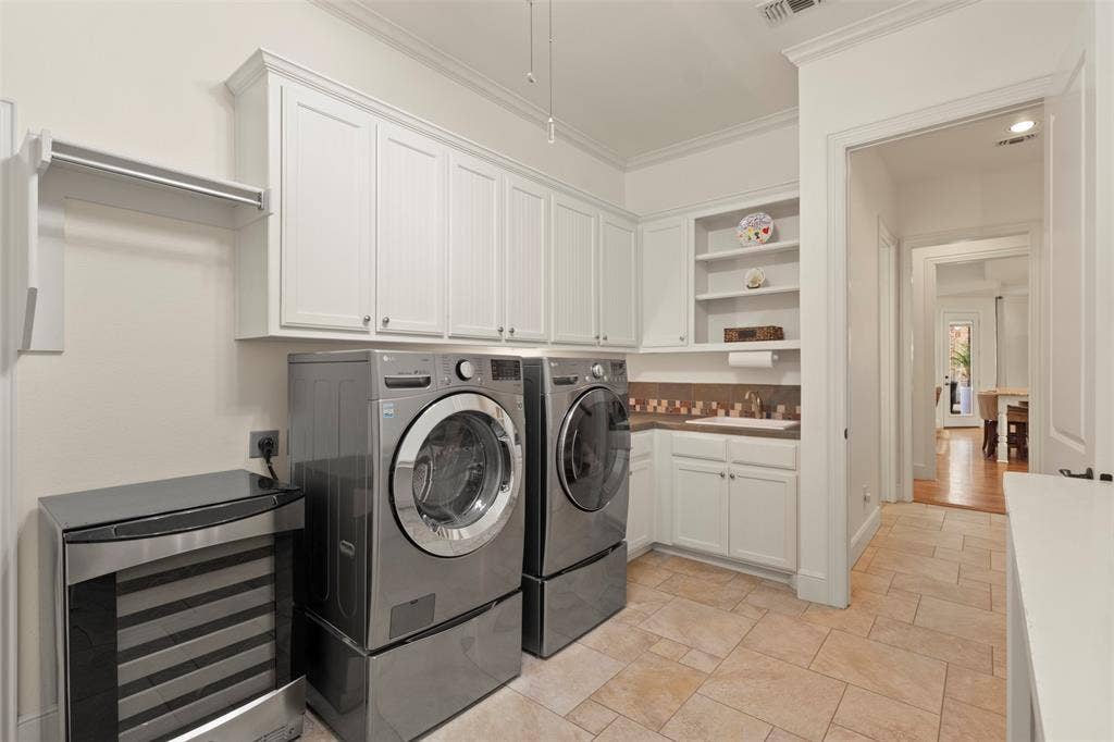 15600 Big Horn Trail, Frisco, TX 75035 Laundry room featuring tile flooring, white cabinetry, a built-in folding rack, and a utility sink with a tiled backsplash