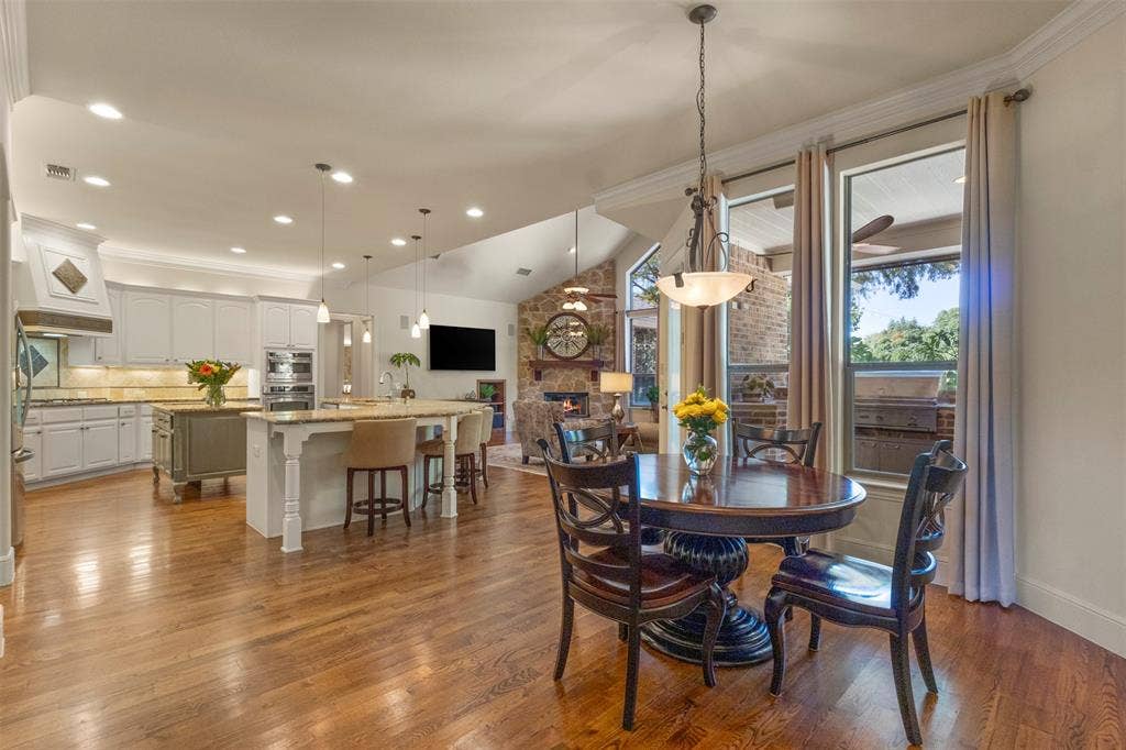 15600 Big Horn Trail, Frisco, TX 75035 Open concept living space featuring wood-finish flooring, vaulted ceilings, and large windows