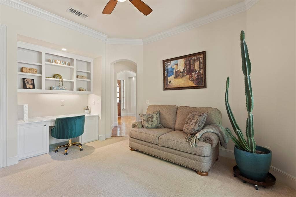 15600 Big Horn Trail, Frisco, TX 75035 Built-in desk with integrated shelving and task lighting, arched doorway, crown molding, and ceiling fan