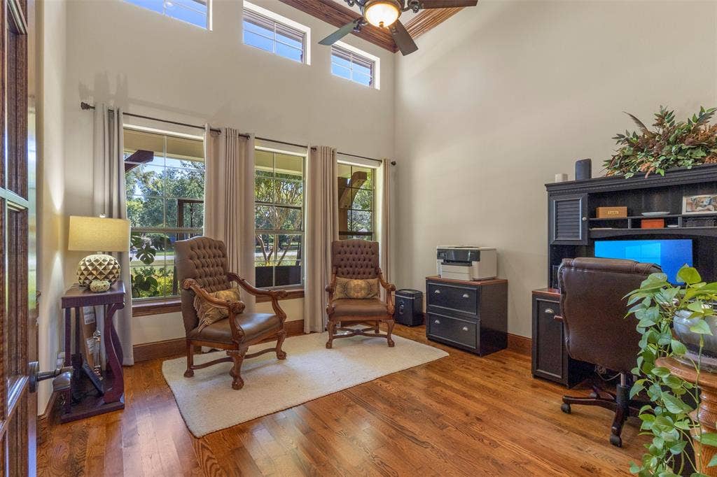 15600 Big Horn Trail, Frisco, TX 75035 High ceilings with upper transom windows, wood-finish flooring, multiple large windows, and a built-in dark wood desk unit