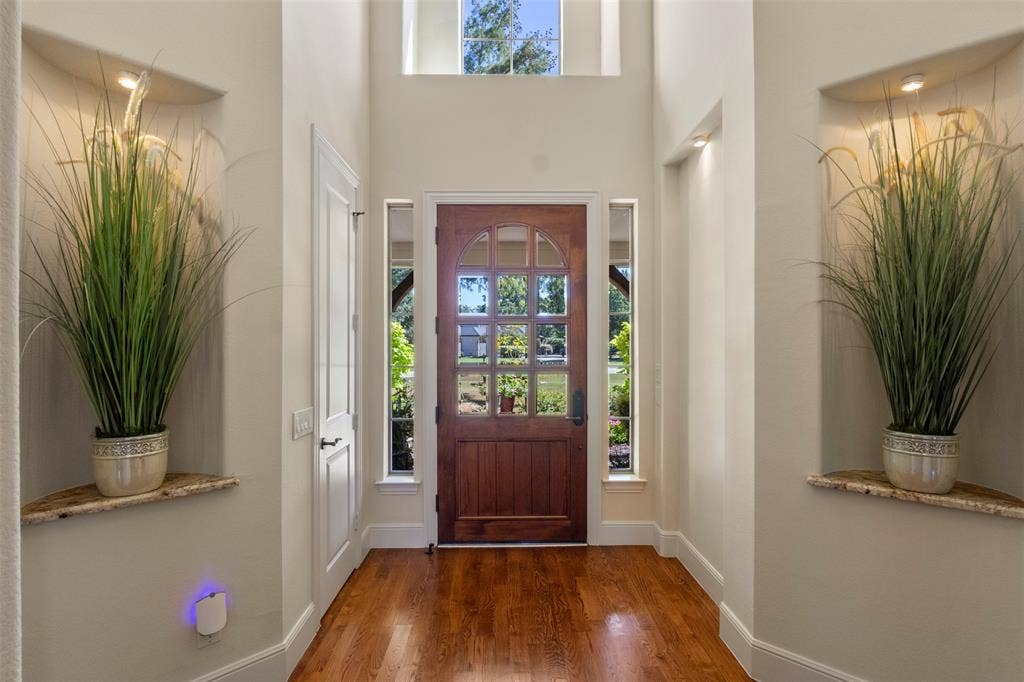 15600 Big Horn Trail, Frisco, TX 75035 Hardwood flooring, arched wood-panel entry door, recessed alcoves with accent lighting, transom window, sidelight windows