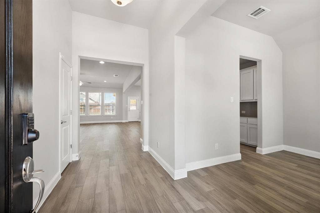 3636 Wintergreen Street, Grand Prairie, TX 76065 Woodlook tile flooring throughout, bright white trim, and a high vaulted ceiling in the entryway