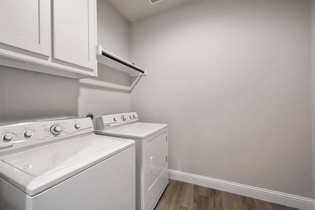 3636 Wintergreen Street, Grand Prairie, TX 76065 Dedicated laundry room featuring side-by-side front-load washer and dryer, white cabinetry and ample counter space for folding and sorting. Washer and dryer stay with the home.