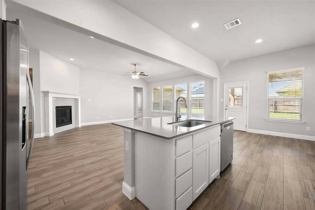 3636 Wintergreen Street, Grand Prairie, TX 76065 Large Kitchen island with an undermount sink, a stainless steel faucet, and a built-in dishwasher