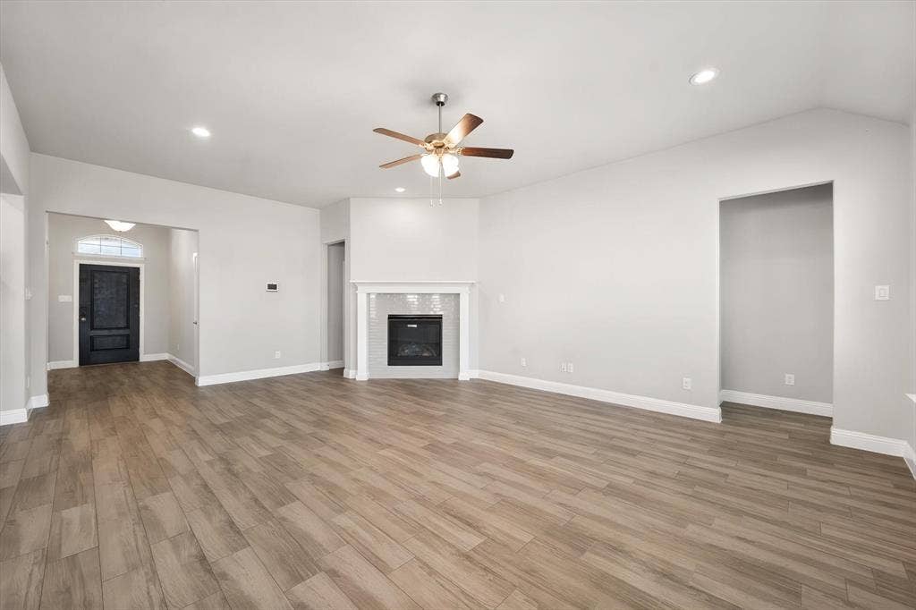 3636 Wintergreen Street, Grand Prairie, TX 76065 Spacious open-concept living area featuring wood-look tile flooring throughout, recessed ceiling lighting, and a ceiling fan with integrated light fixture