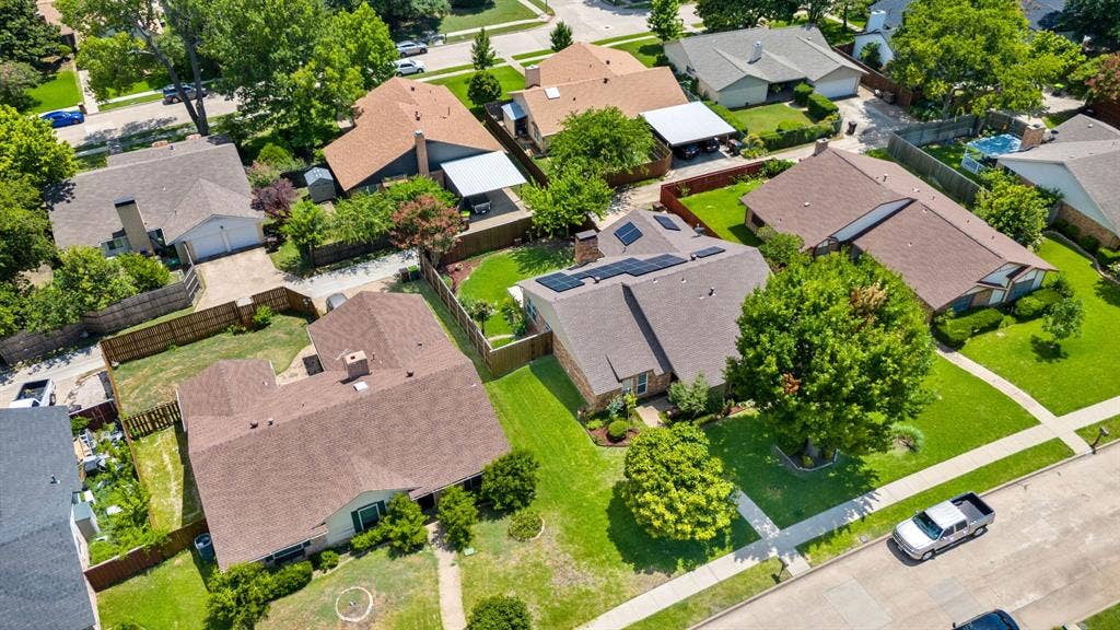 Residential property with a brown shingle roof and solar panels