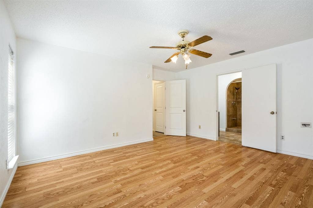 Interior space featuring wood-finish flooring, a ceiling-mounted light fixture with a fan, and solid-core interior doors