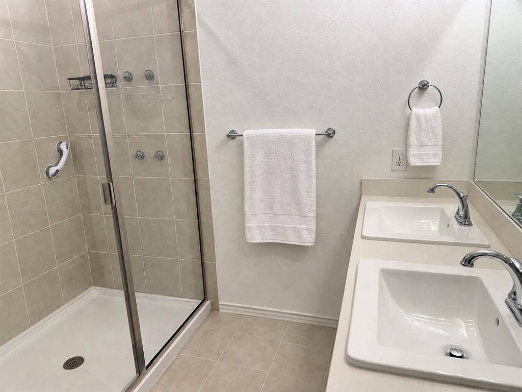 5719 Huffines Boulevard, Royse City, TX 75189 Glass-enclosed shower with a tiled surround, dual vanity with undermount sinks, chrome fixtures, and tiled flooring