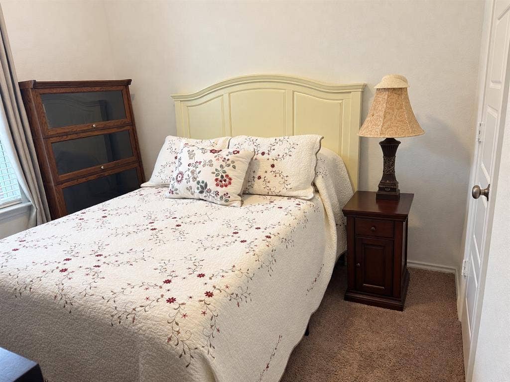5719 Huffines Boulevard, Royse City, TX 75189 Carpeted room featuring a window with blinds, a solid door, and a light-colored headboard