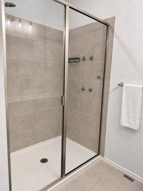 5719 Huffines Boulevard, Royse City, TX 75189 Glass-enclosed shower featuring a rain shower head, body jets, and tiled walls