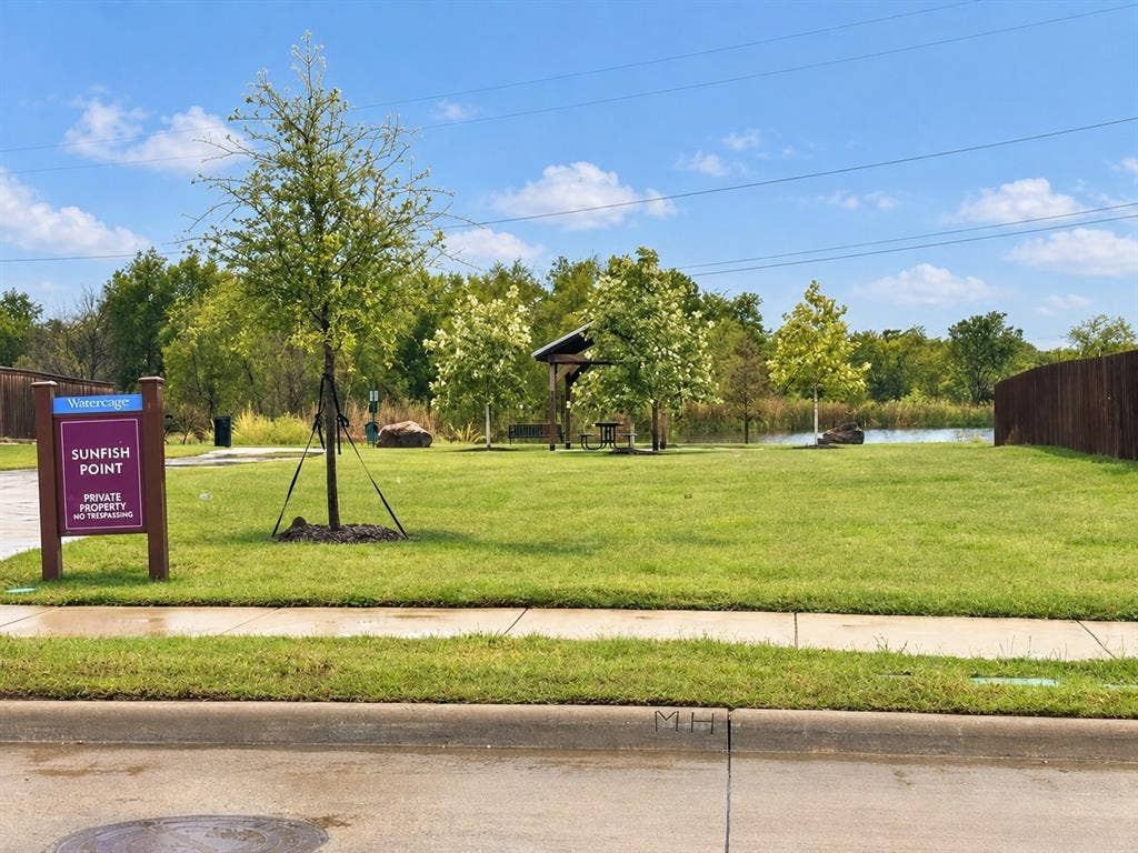 5719 Huffines Boulevard, Royse City, TX 75189 Expansive green space featuring a water element, mature trees, and a wooden gazebo