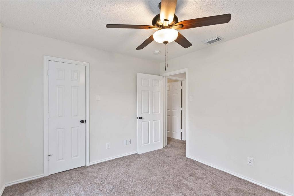 Neutral-toned interior room featuring light gray carpeting and white walls