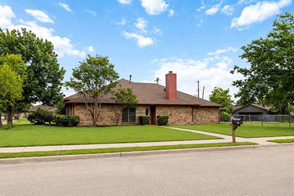 Brick exterior featuring a gabled roof and red brick chimney
