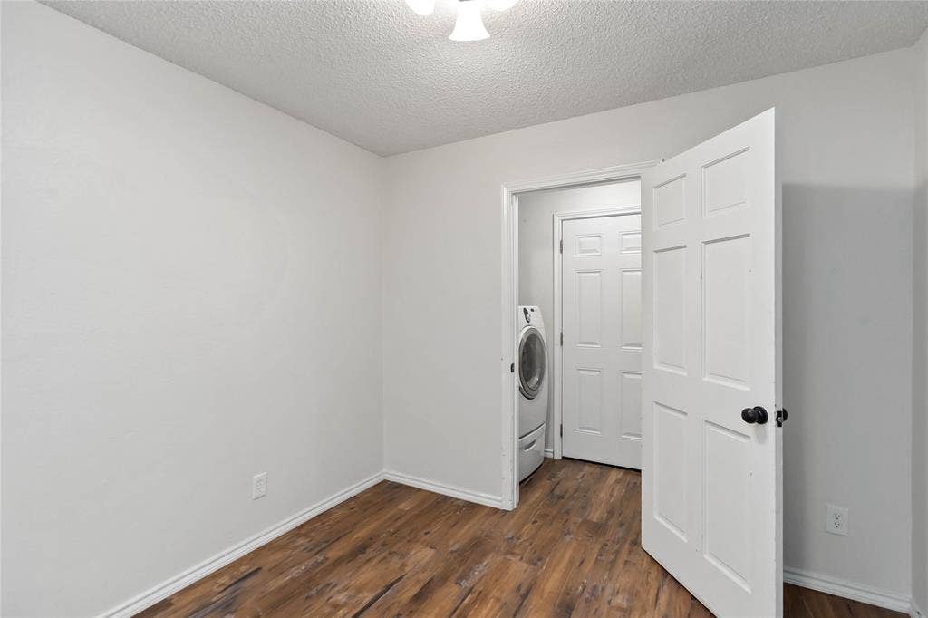Interior room featuring wood-finish flooring, white baseboards, and light neutral wall paint