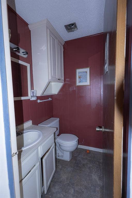 1723 W Waco Drive, #1725, Waco, TX 76707 White vanity with integrated sink, paneling, and an overhead storage cabinet