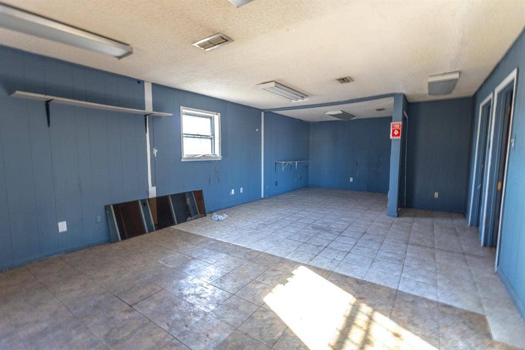 1723 W Waco Drive, #1725, Waco, TX 76707 Spacious interior with tile flooring, wall-mounted shelving, and multiple entryways