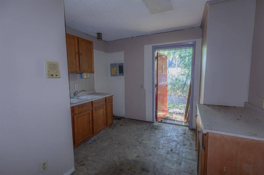 1723 W Waco Drive, #1725, Waco, TX 76707 Wood-finish cabinetry, built-in sink, and a rear exterior door
