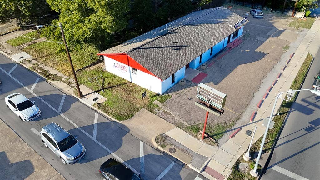 1723 W Waco Drive, #1725, Waco, TX 76707 Single-story building with a shingle roof, extensive paved lot, and prominent street signage