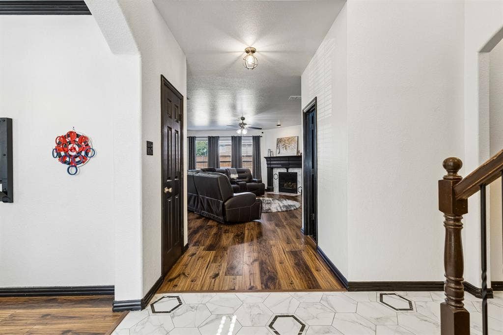 Updated Finishes Make a Statement – The entry introduces the home's distinctive style with decorative hexagon tile flooring, contrasting black trim and doors, and a seamless transition into the spacious family room with waterproof laminate flooring.