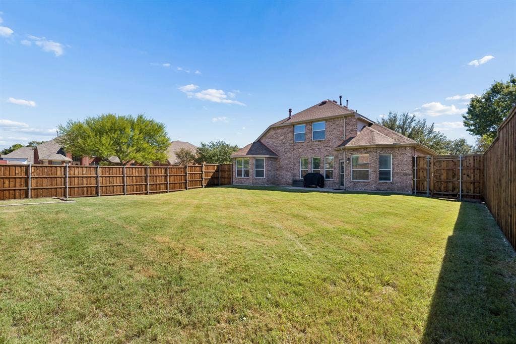 A Backyard Full of Possibilities – The expansive backyard offers a wide-open lawn surrounded by a wood privacy fence, providing plenty of room for outdoor entertaining, gardening, recreation, or creating your own outdoor retreat.
